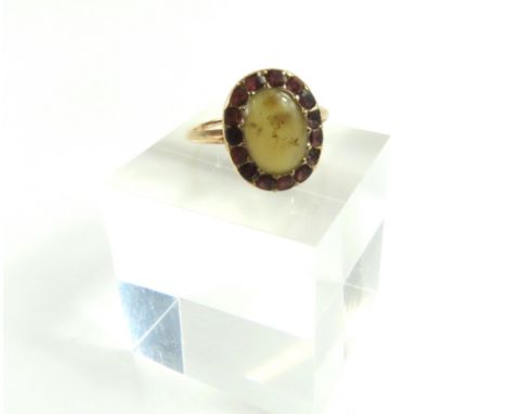 A Georgian or early Victorian foil backed flat cut garnet and cream stone cluster ring, the cream stone appears to be dendrit
