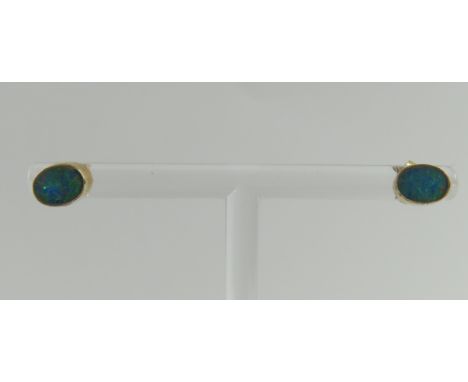A pair of 9ct gold opal doublet stud earrings, the oval stones in a rub over setting with beaded edge, 1g gross