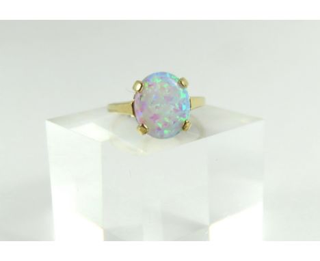 A 9ct gold white opal dress ring, the single oval cabochon cut stone in a four claw setting, approximately 11.9mm x 9.8mm, fi