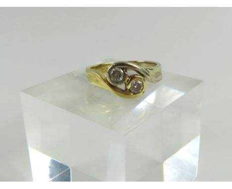 A two colour gold two stone diamond twist ring, marked '750', finger size J1/2, 3.4g gross