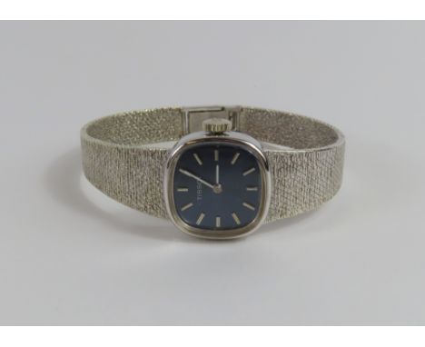 Tissot - a ladies 9ct white gold manual wristwatch, the blue square dial with rounded corners, the silver baton hour markers 