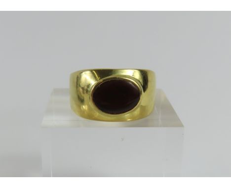 A green opal ring, the oval cabochon cut stone rub over set lengthways, marked '750', finger size P1/2 leading edge at back o