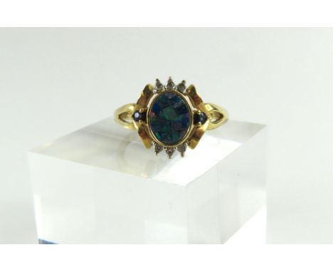 A 9ct gold mosaic opal, sapphire and diamond dress ring, the opal pieces set onto an oval hardstone with a single sapphire to