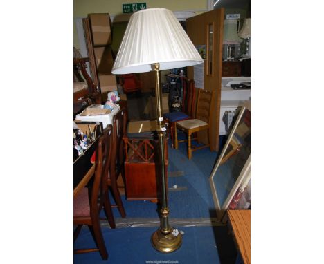 A brass standard lamp and shade.