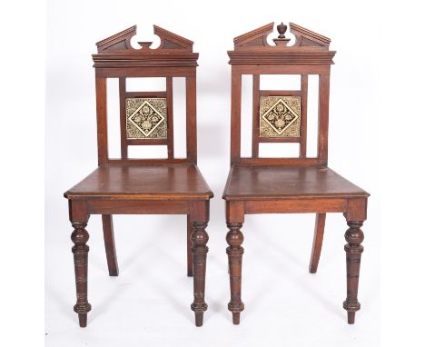 A pair of Victorian oak and glazed tile inset hall chairs, in Aesthetic Movement style, late 19th century; the backrests each