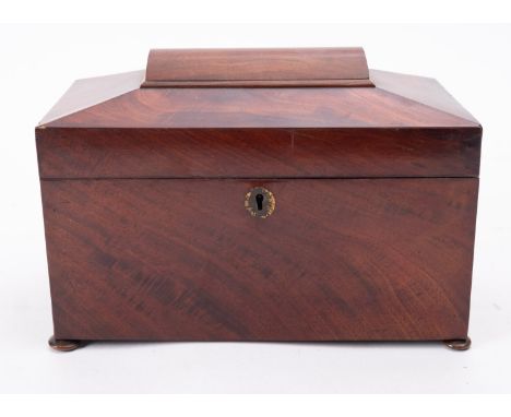 A Regency mahogany caddy, early 19th century; of sarcophagus form, on disc feet; the interior with an associated glass tumble