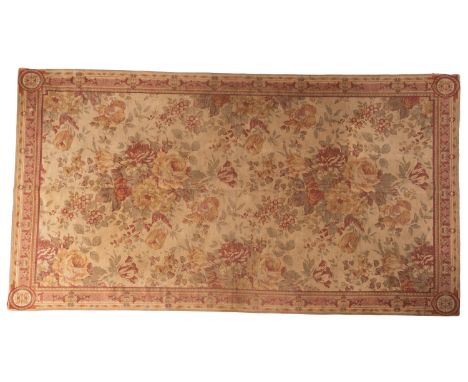 A machine made tapestry, in Savonnerie style, the beige field with a design of floral sprays, 290cm x 168cm.




