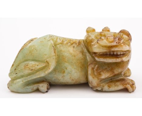 A Chinese jade figure of brown flecked celadon colour modelled as recumbent lion dog, 15cm long, with carved wooden stand.

