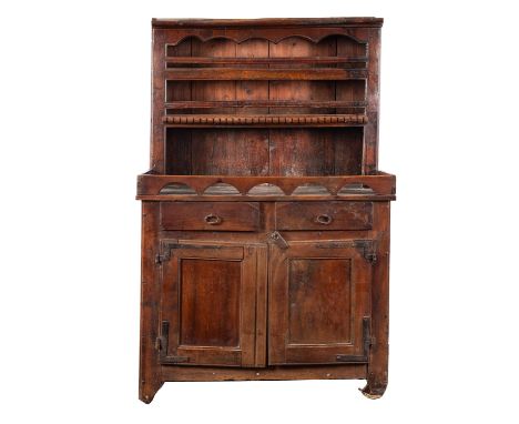 A Continental provincial walnut dresser, elements 18th century and later; with cornice and multi-arched canopy above the plat