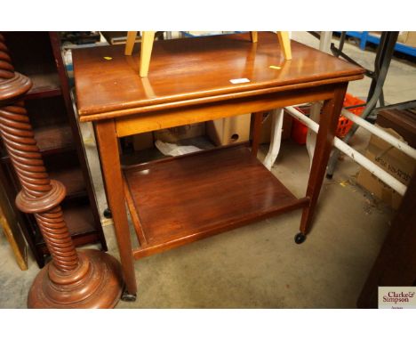 A two-tiered tea trolley with foldover card table top