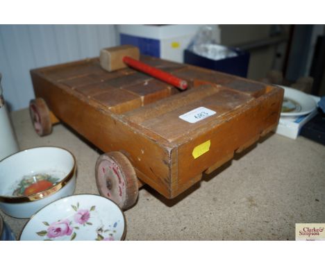 A vintage wooden toy trolley and contents of building bricks