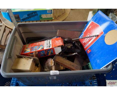A box containing tools, brackets, brass screws, sandpaper etc.