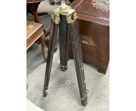 A vintage wooden and brass stand for a theodolite.