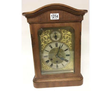 A walnut cased mantel clock with a brass dial silvered chapter ring three train movement.Hight 40cm