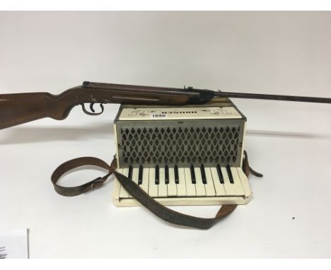 An old Air gun and and a Hohner accordion. (2)