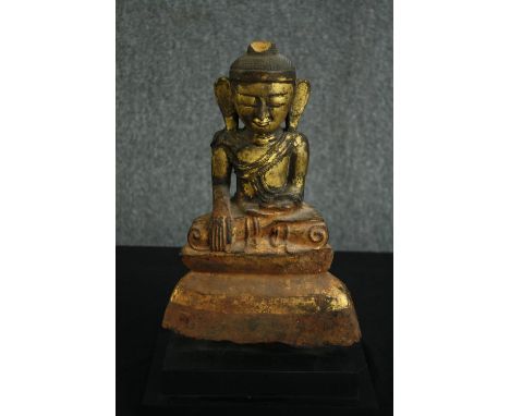 † A 19th century Chinese painted and gilded ceramic buddha in lotus position. H.39cm. 