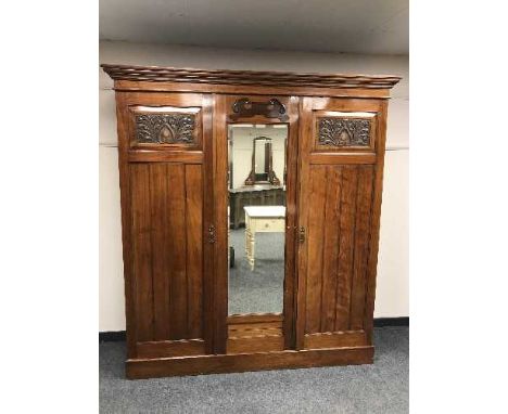 An Edwardian mahogany triple door mirrored wardrobe