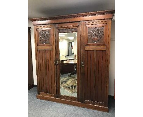 A late Victorian mahogany triple door mirrored wardrobe