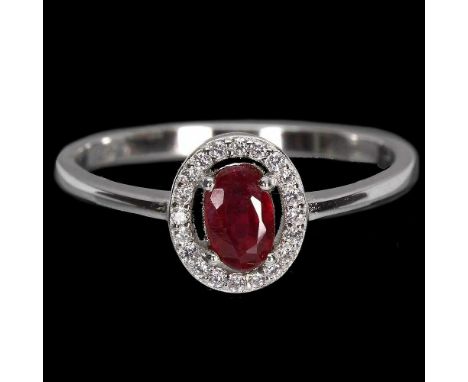 A 925 silver halo ring set with an oval cut ruby surrounded by white stones, (O).