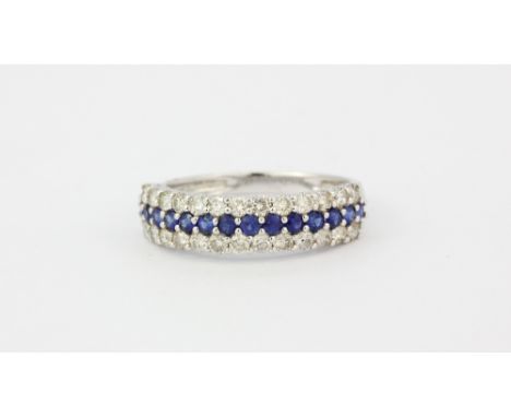 An 18ct white gold half eternity ring set with brilliant cut sapphires flanked by two rows of diamonds, (M).