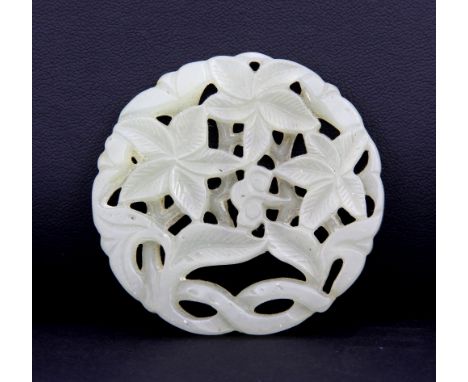 A Chinese carved circular celadon jade panel decorated with flowers, Dia. 5cm.