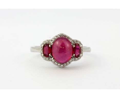 A 925 silver ring set with a cabochon cut ruby, two oval cut rubies and white stones, (Q).