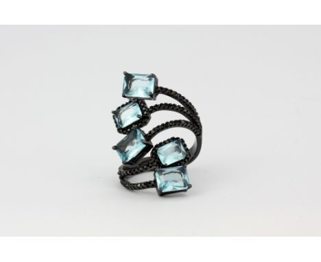 A 925 silver crossover ring set with scissor cut blue stones and black spinels, (O.5)