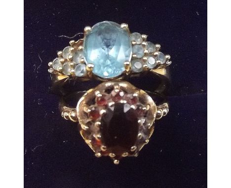 A 9 carat gold garnet cluster ring, size K and a 9 carat gold ring set blue topaz, size 0 (one stone deficient)