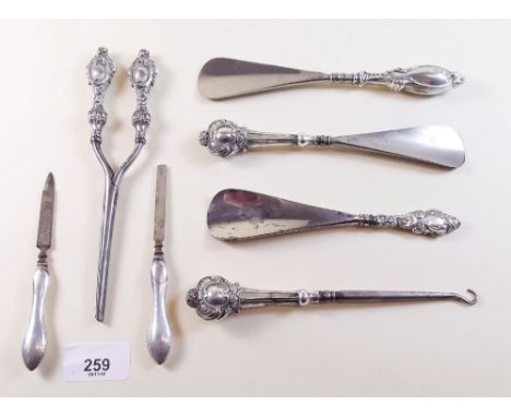 A pair of silver handled glove stretchers, three shoe horns, button hook and two manicure tools