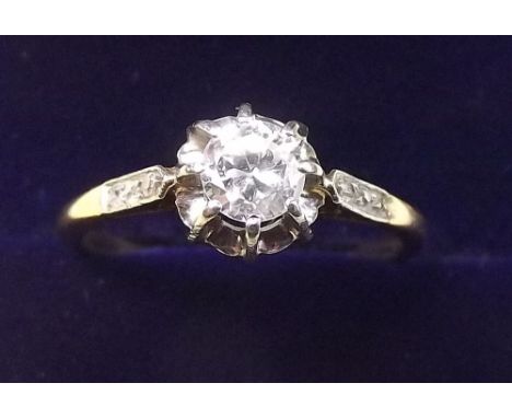 An 18 carat gold solitaire diamond ring on chip diamond set shoulders (unmarked) - size L