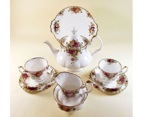 A Royal Albert Country Roses tea service comprising: teapot, six cups and saucers, six tea plates, cake plate, milk and sugar