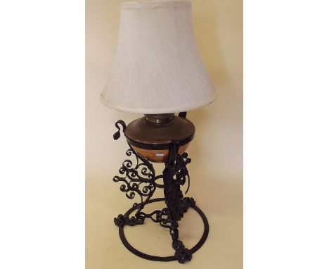 A copper oil lamp on wrought iron stand