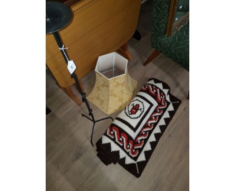 A CAST METAL STANDING CANDLE HOLDER AND A RUG AND A LAMP SHADE