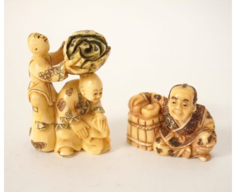 JAPANESE CARVED IVORY NETSUKE
of a man seated by a barrel, 3cm high; and a Japanese ivory netsuke of two men, one holding a c