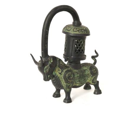 CHINESE METAL LAMP
modelled as an Ox, with a shaped carrying handle and pierced candle holder, decorated with mythical creatu