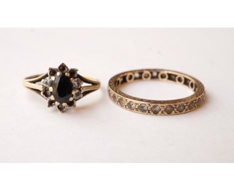 GEM SET ETERNITY RING
in nine carat gold, ring size P; and a sapphire and CZ cluster ring (stones lacking) on nine carat gold