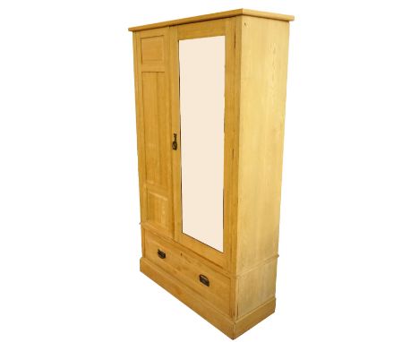 EDWARDIAN LIGHT OAK WARDROBE
with a bevelled mirror door above a single frieze drawer, standing on a plinth base, 194.5cm hig