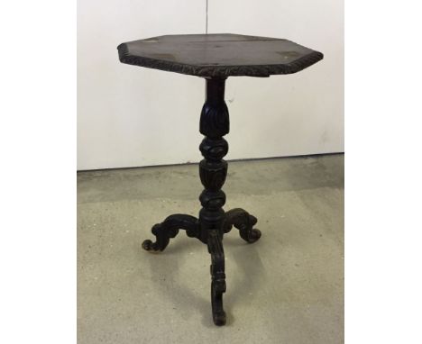 A carved wood tripod wine table.