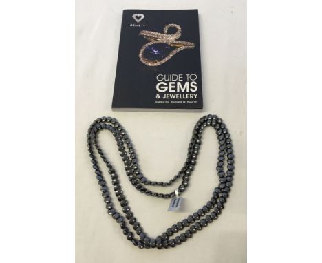 A boxed 48 inch haematite necklace with a Guide to Gems & Jewellery book.