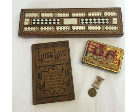 An inlaid cribbage board, a Ward & Lock's books 'A Long Life & How to Reach it' and a commemorative tin.