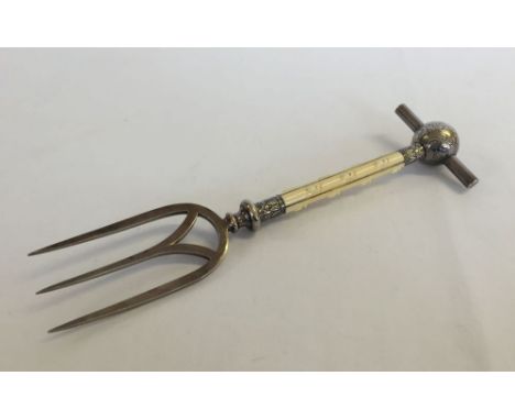 An ornate silver plated meat fork with faux ivory handle. Approx 26cm long.