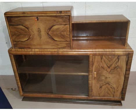 An early 20th century stained and grained bookcase / cocktail cabinet with fall front, sliding glass door and single cupboard