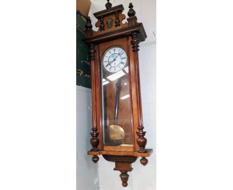 A 19th century Vienna wall clock in walnut case with carved pediment, half turned and reeded side columns, white dial and sin