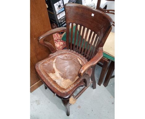 A 1930's oak armchair with ladder back, on turned legs (seat requires upholstering); an early 20th century oak office armchai