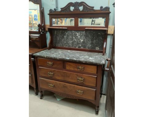 An Edwardian walnut washstand with 2 long and 2 short drawers with brass drop handles, marble top and back with mirror and di