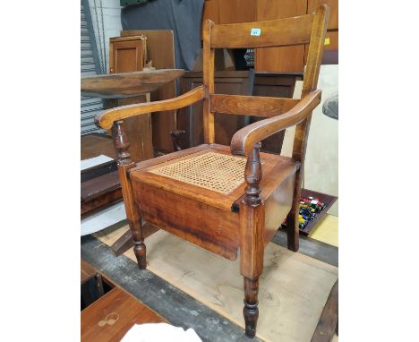 A late 19th/early 20th century commode chair with hinged rush seat 