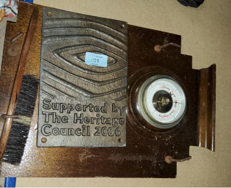 A wall barometer and a Heritage council plaque 