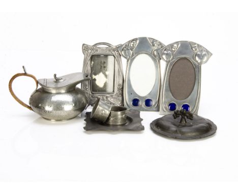 An Art Nouveau continental pewter photograph frame, the shaped outline with floral decoration and whiplash design together wi