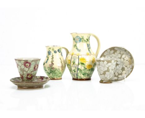 Two terracotta glazed jugs, with sgraffito floral decoration, sunflowers and the other foxgloves with strap handles, together