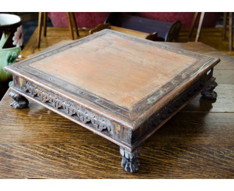 An Indian hardwood and metal mounted square table top stand, with painted red oak centre surrounded by a hardwood surround pi